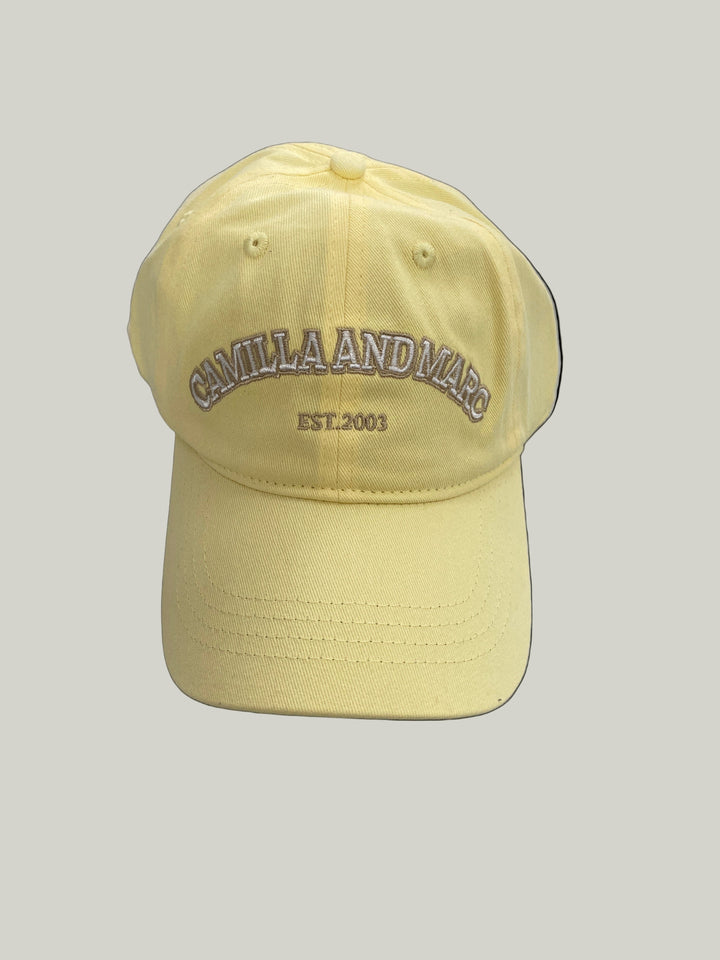 Yellow cap with branding on a light gray surface